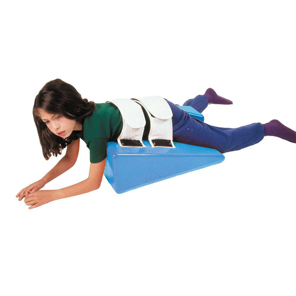 A person lies on a blue Skillbuilders Strap Wedge, secured with white straps. They are wearing a green shirt and purple socks.