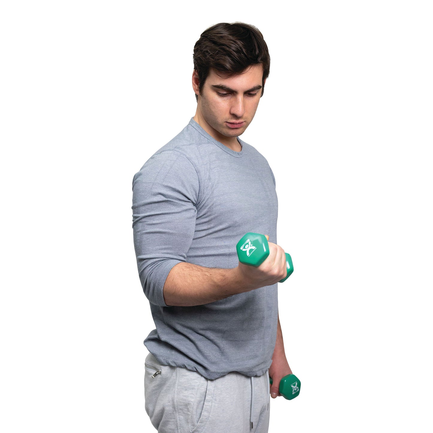 A man lifts a green dumbbell from the CanDo Vinyl-Coated Dumbbell Set, wearing a gray long-sleeve shirt and pants.