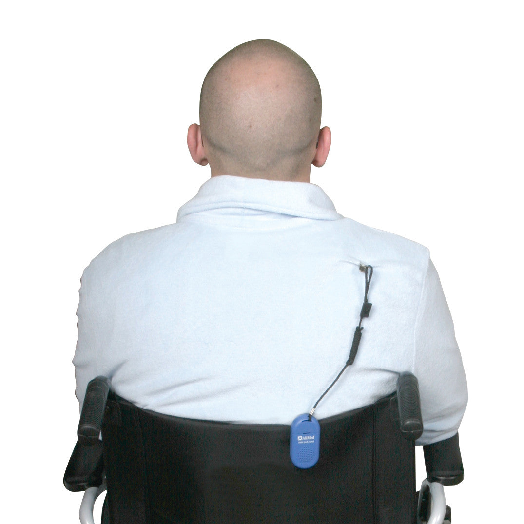 A person in a wheelchair wears an AliMed Worry-Free Pull-Cord Alarm attached to the chair's back.