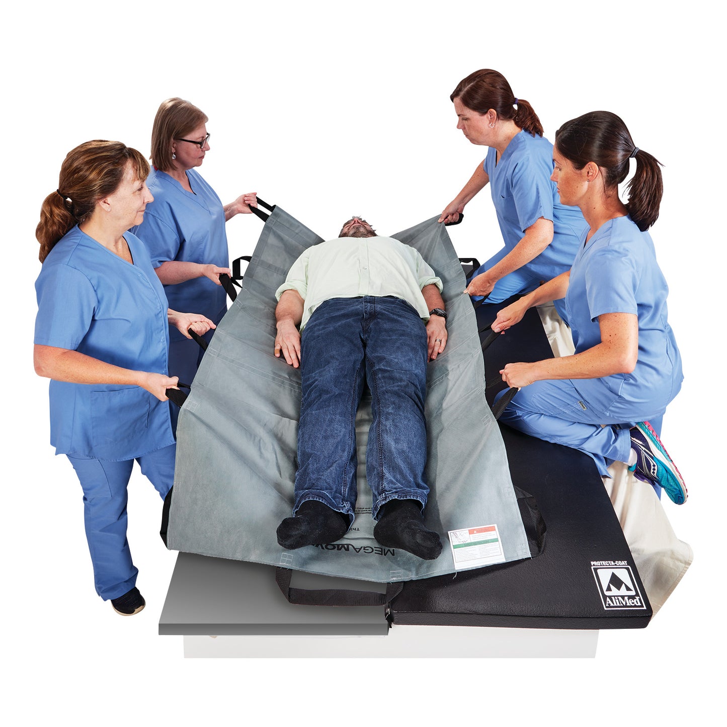 Four people in blue uniforms use the Graham Medical MegaMover 1500 Transport Unit to lift a person lying on a gray transport mat.