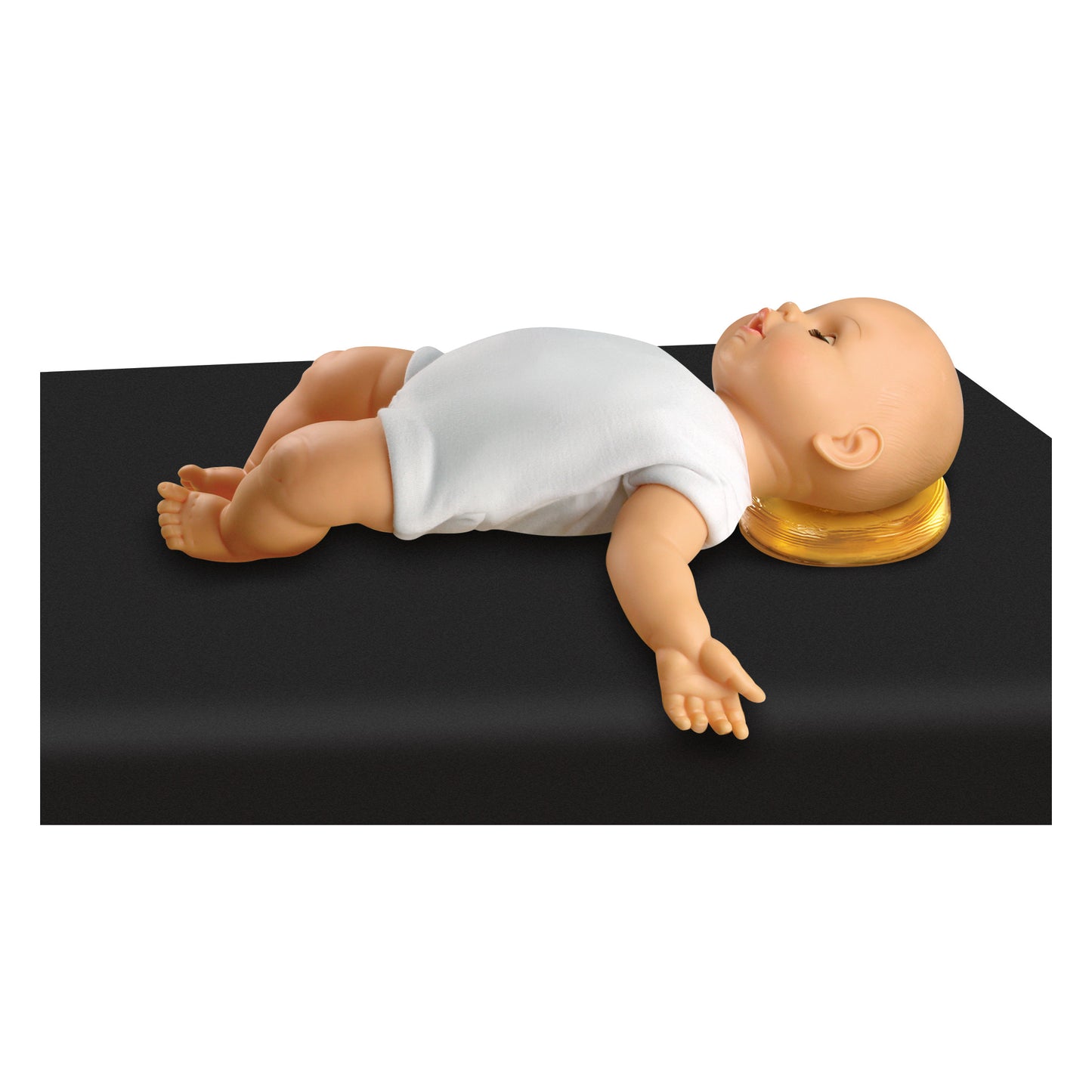 A doll lying on a black surface using the AliMed AliGel Head Donut as a cushion, wearing a white onesie.
