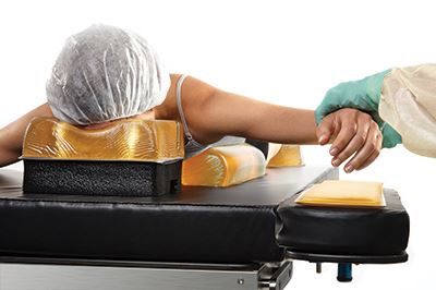 nurse putting patient on positioners on operating table
