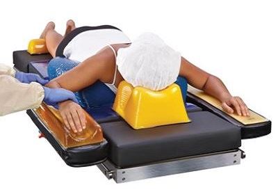 surgeon positioning patient on operating table with patient positioners