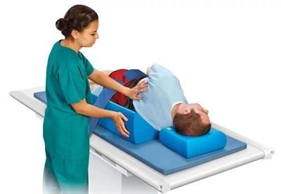 nurse putting positoning wedges under patient on table