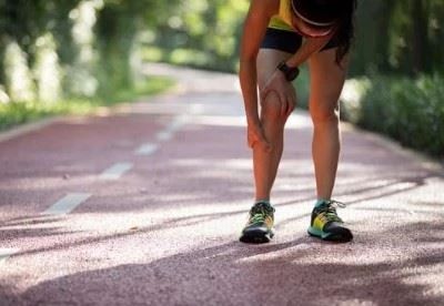 woman holding her shin after walking