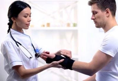 nurse putting on wrist brace on patient