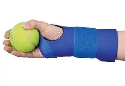 person holding tennis ball with carpal tunnel support on wrist