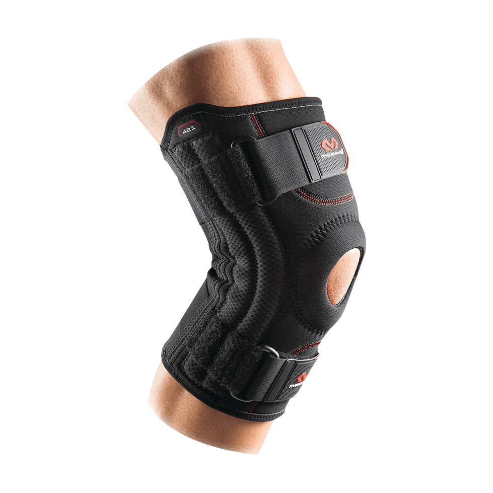 A person wearing the McDavid Patella Knee Support, a black brace with adjustable straps and an open patella design.