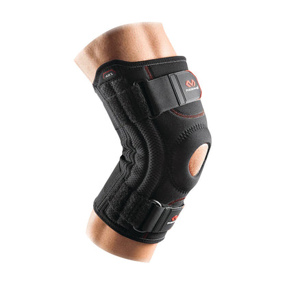 A person wearing the McDavid Patella Knee Support, a black brace with adjustable straps and an open patella design.